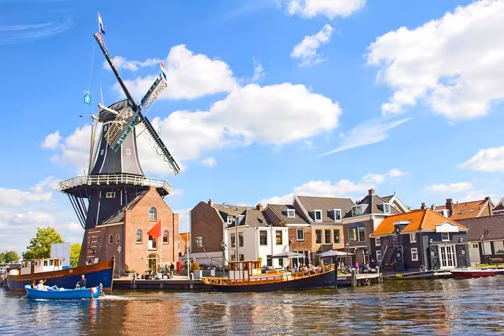 Cyclists pass Haarlem’s iconic De Adriaan windmill and canalfront on a Highlight Bike Tour Haarlem