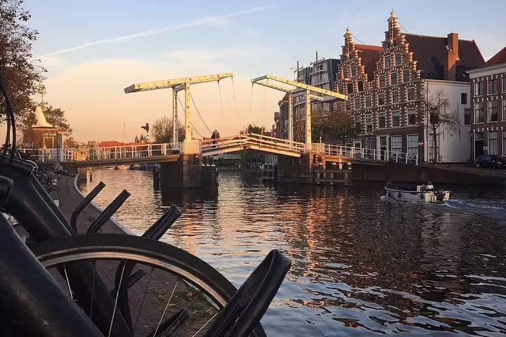 Haarlem canal drawbridge at sunset with boats and historic gabled buildings on North Sea dunes day trip