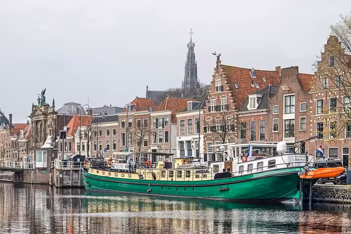 Canal view in Haarlem with historic houses and a green ship, scenic stop on Highlight Bike Tours Haarlem