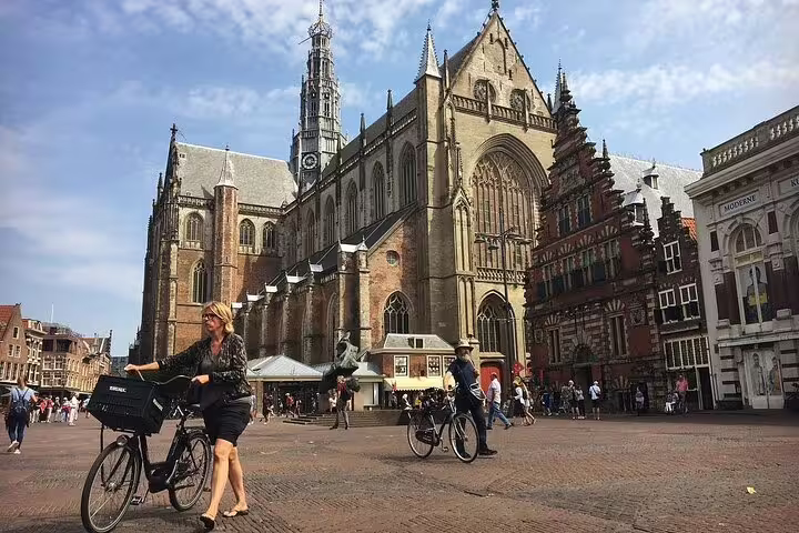 Cyclists in Haarlem Grote Markt with St. Bavo Church, highlight of Your Own Holland private day tour