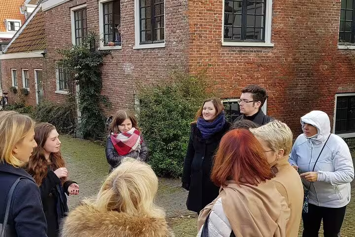 Small group tour in Haarlem old town, local guide sharing stories beside historic Dutch brick buildings