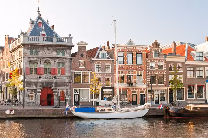 Haarlem Spaarne riverfront with Dutch gabled houses and sailboat, highlight stop on Haarlem bike tour