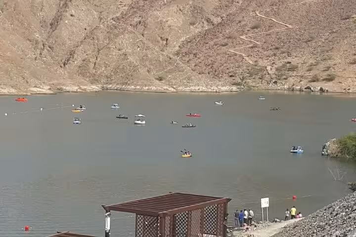 Hajar Mountains lake with boats near Fujairah, panoramic viewpoint on Khorfakkan mountains safari tour