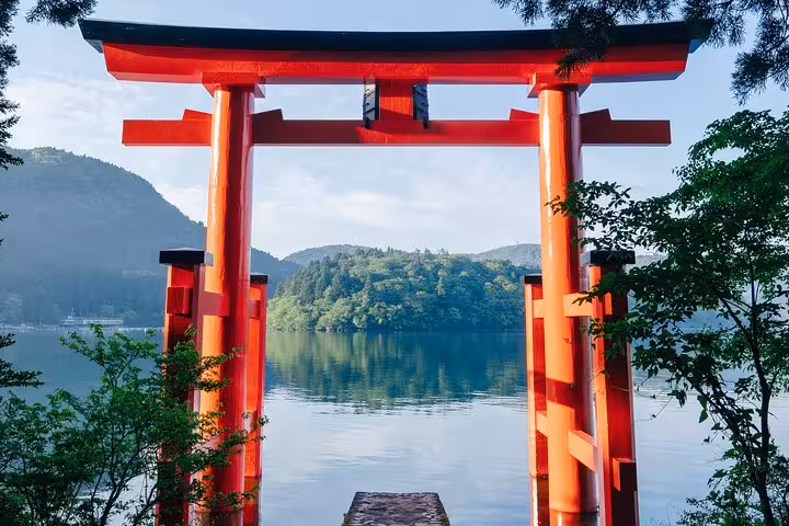 Iconic red torii gate at Lake Ashi, symbolizing spiritual beauty and tranquility in Hakone's landscape.