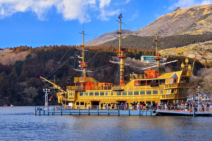 Close-up of a traditional pirate ship docked at Lake Ashi, surrounded by lush mountains on a Hakone guided tour.