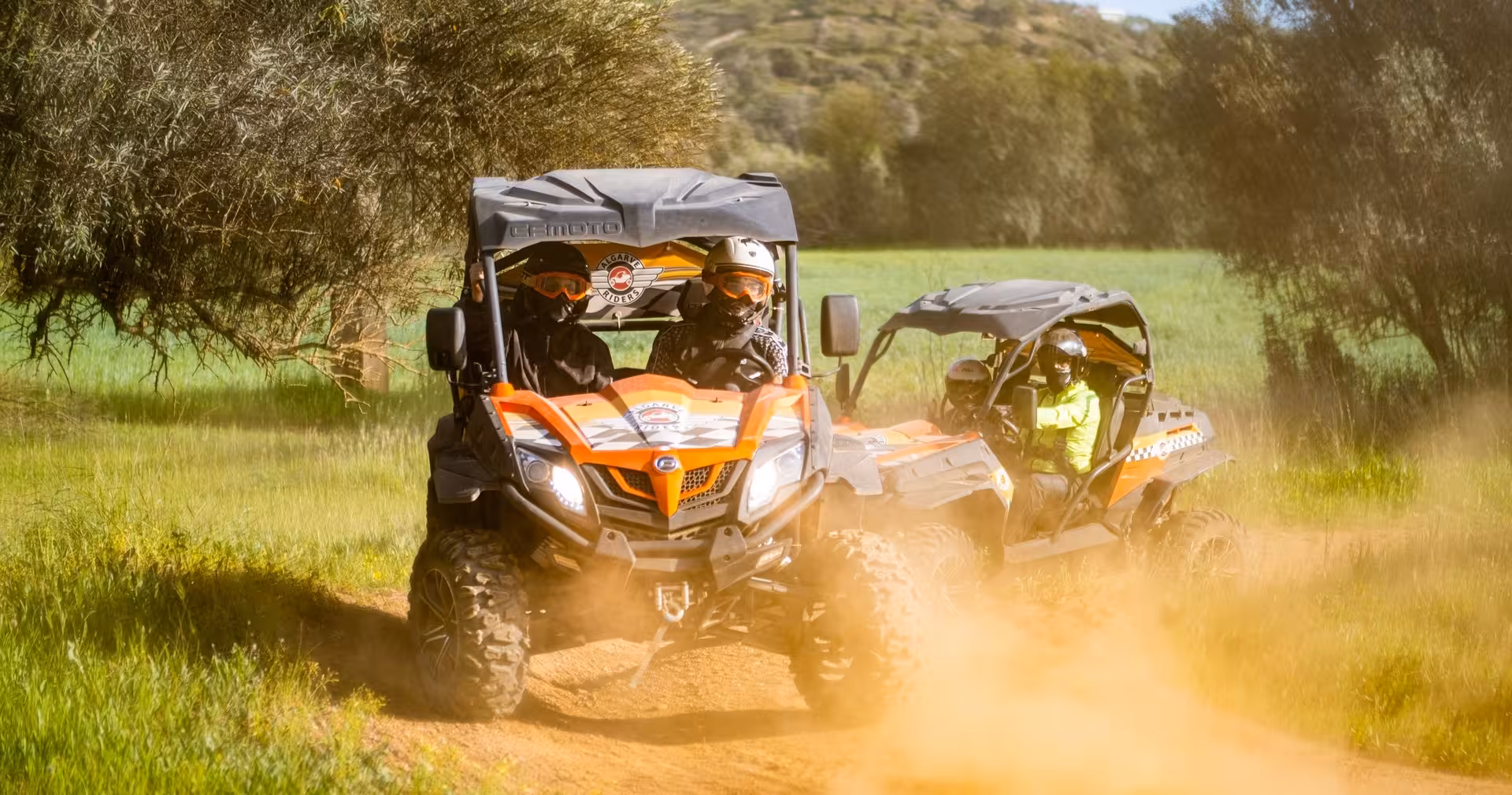 Group half-day buggy tour driving through green fields and dirt trails in Algarve, offering fun off-road adventure for all levels