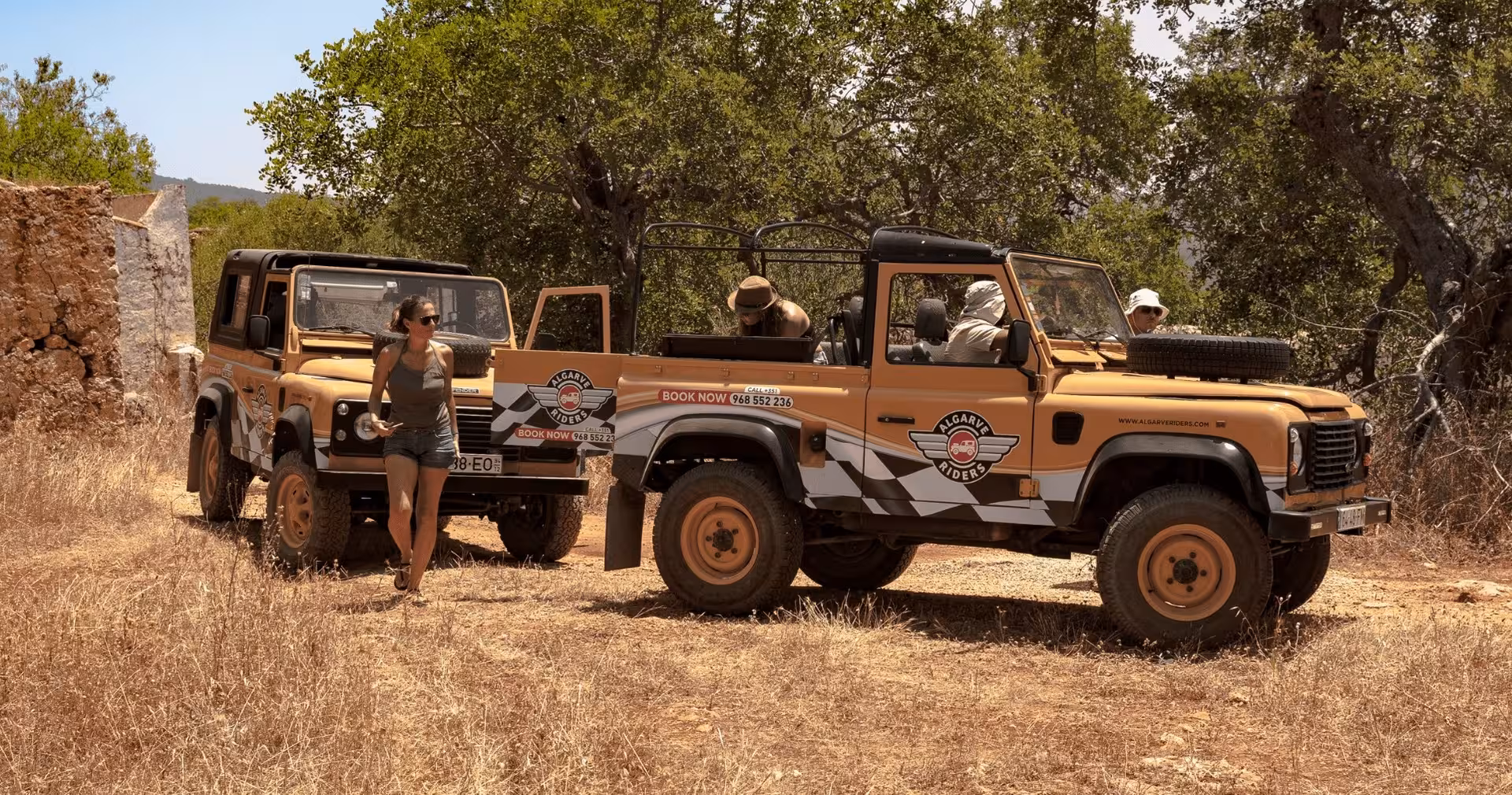 Guests exploring rural Algarve beside branded safari jeeps parked near old stone ruins on a half-day private tour