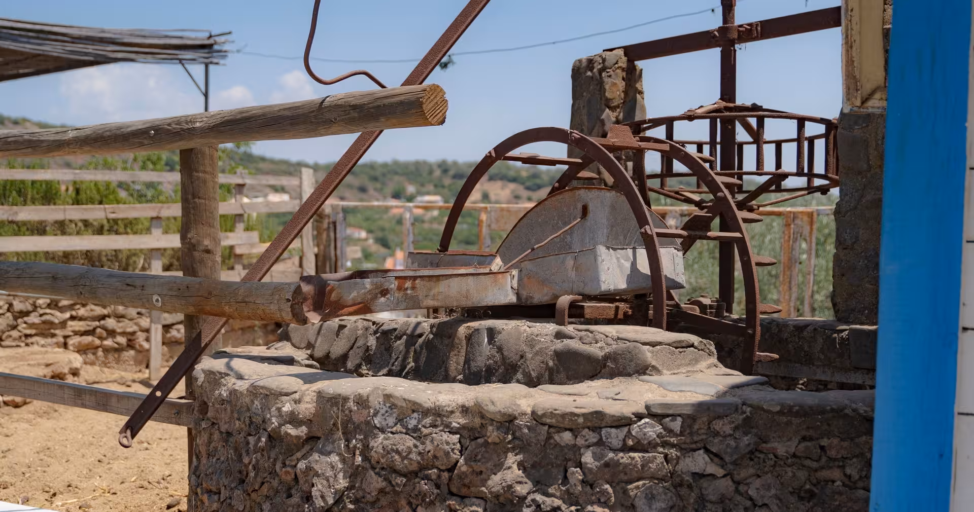 Rustic stone well and old farm machinery visited on a cultural stop during a guided half-day private safari tour