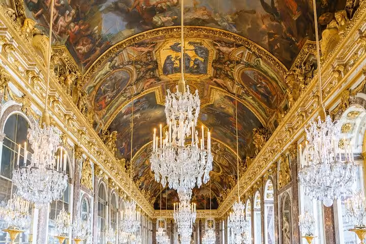 Hall of Mirrors at Palace of Versailles on a guided grand tour, gilded ceilings and crystal chandeliers
