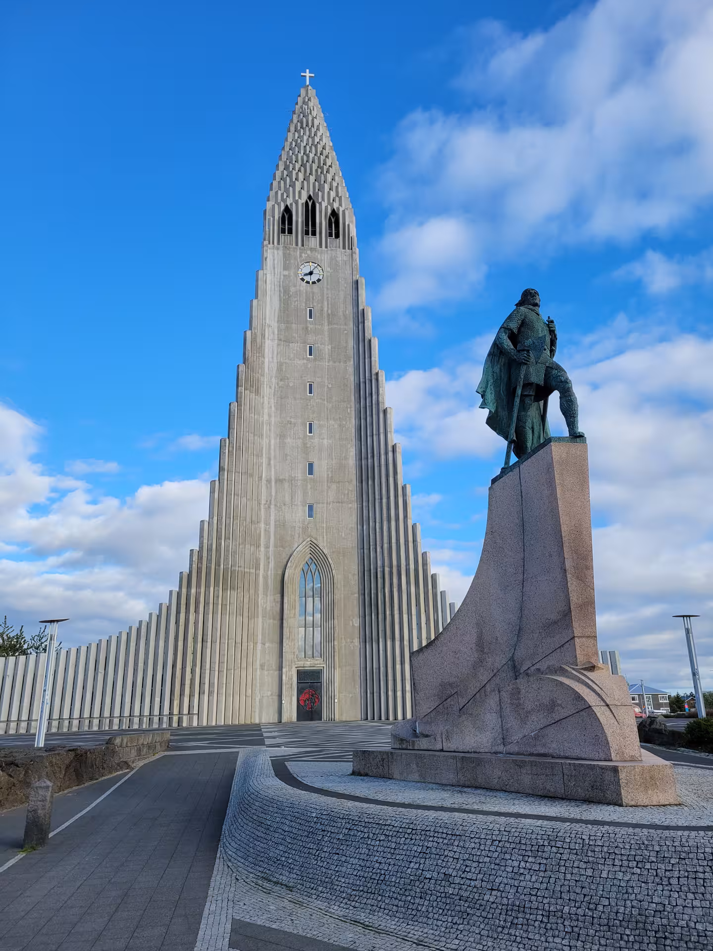 Majestic Hallgrimskirkja church in Reykjavik stands tall against a blue sky, a must-see on your Icelandic journey.