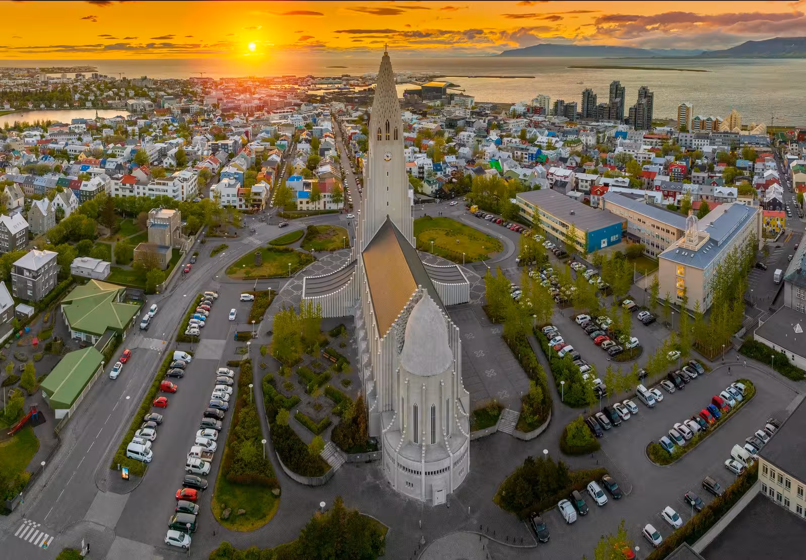 Aerial view of Hallgrimskirkja church at sunset overlooking Reykjavik cityscape, ideal for Northern Lights tours.