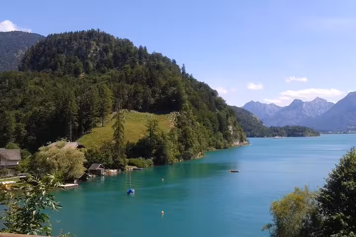 Turquoise alpine lake and forested hills in Salzkammergut, scenic stop on Hallstatt small-group day trip from Vienna