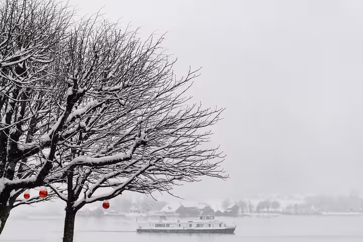 Snowy lake view with winter boat, perfect for small-group Christmas Day trip to Hallstatt from Vienna