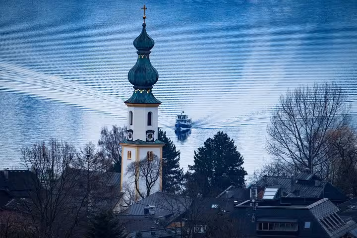 Hallstatt church tower above rooftops with boat on the lake, featured on small-group Christmas Day trip from Vienna