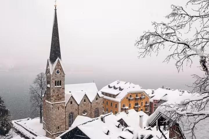 Hallstatt church tower and snow-covered rooftops by Lake Hallstatt, winter stop on Vienna private day trip