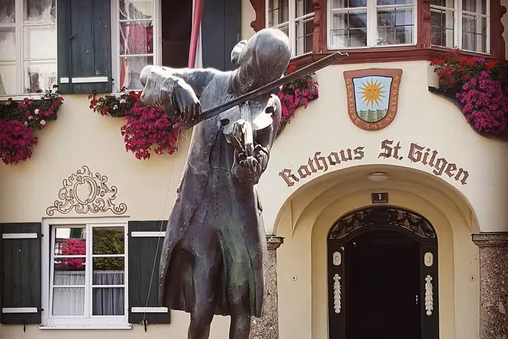 St. Gilgen Rathaus violin statue with flowered balconies, scenic stop on Hallstatt small-group day trip from Vienna