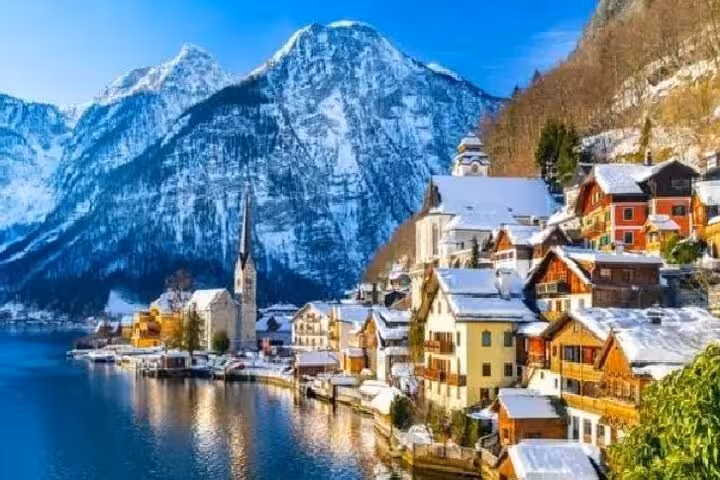 Snowy Hallstatt lakeside village with church and Alps, private day trip from Vienna to Salzburg and Melk