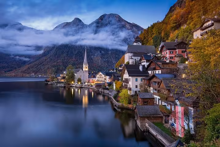 Hallstatt lakeside village at dusk with church spire and Alps, highlight of small-group day trip from Vienna Austria
