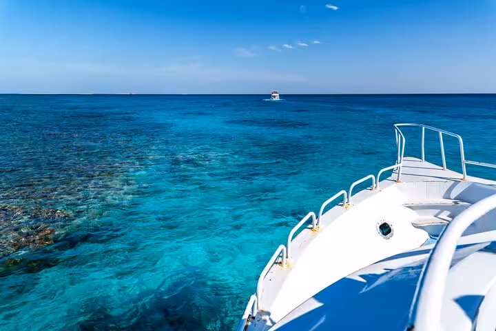 Boat bow over crystal-clear Red Sea reef on Hamata Islands snorkeling trip from Marsa Alam with lunch
