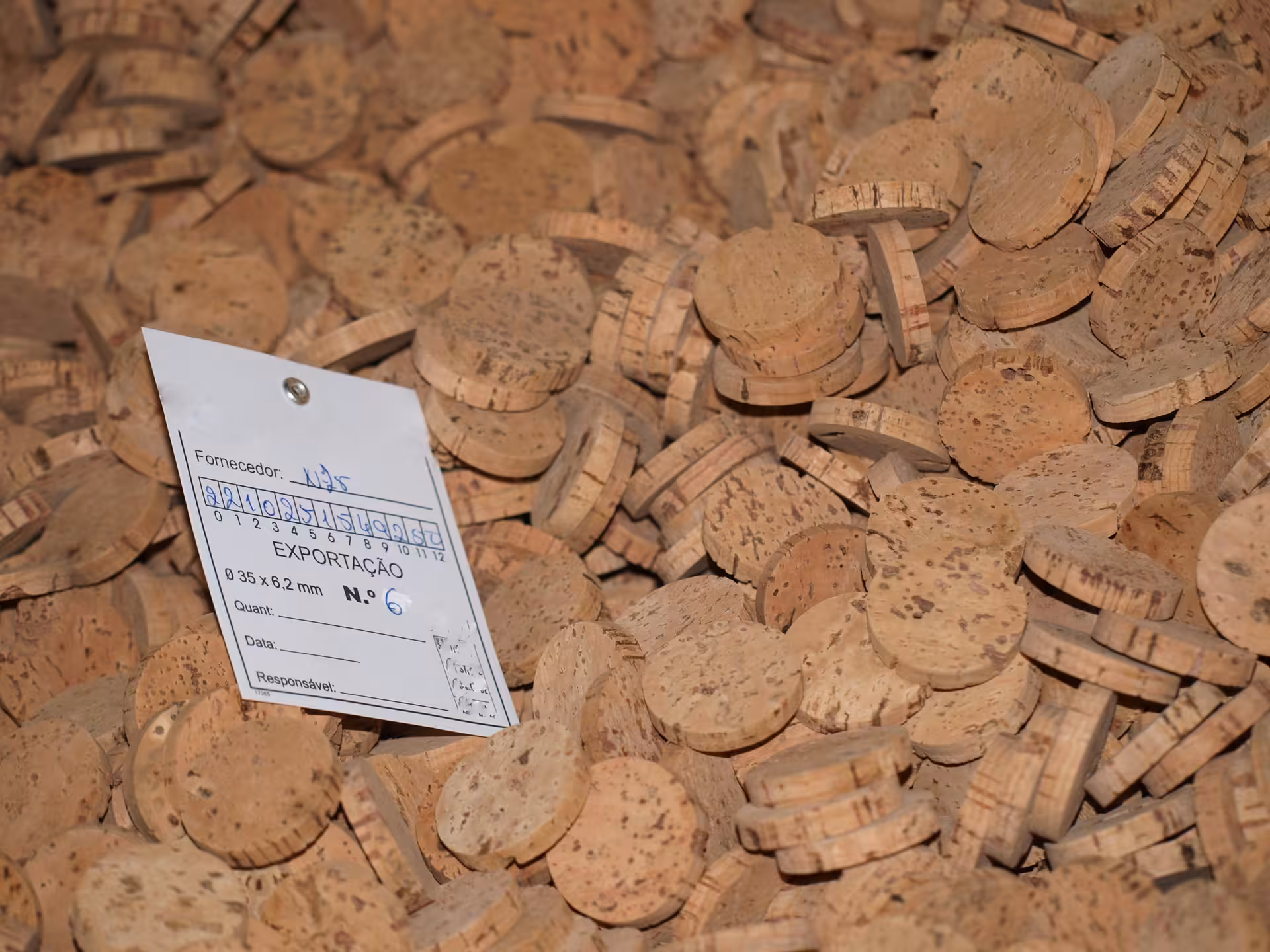 Handcrafted cork discs labeled for export at a traditional Algarve cork factory, part of a local heritage tour