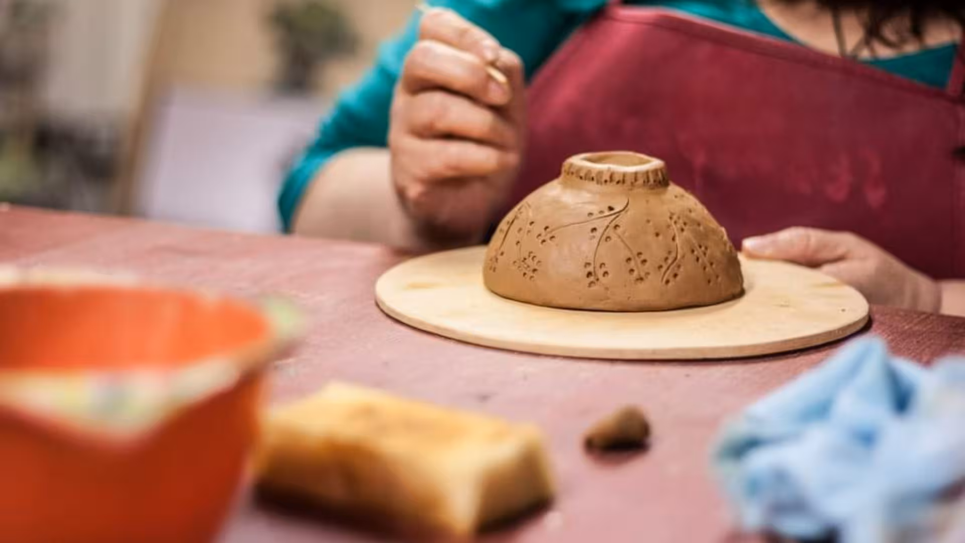 Close-up of a handmade ceramic bowl being intricately carved during a Cagliari pottery workshop.