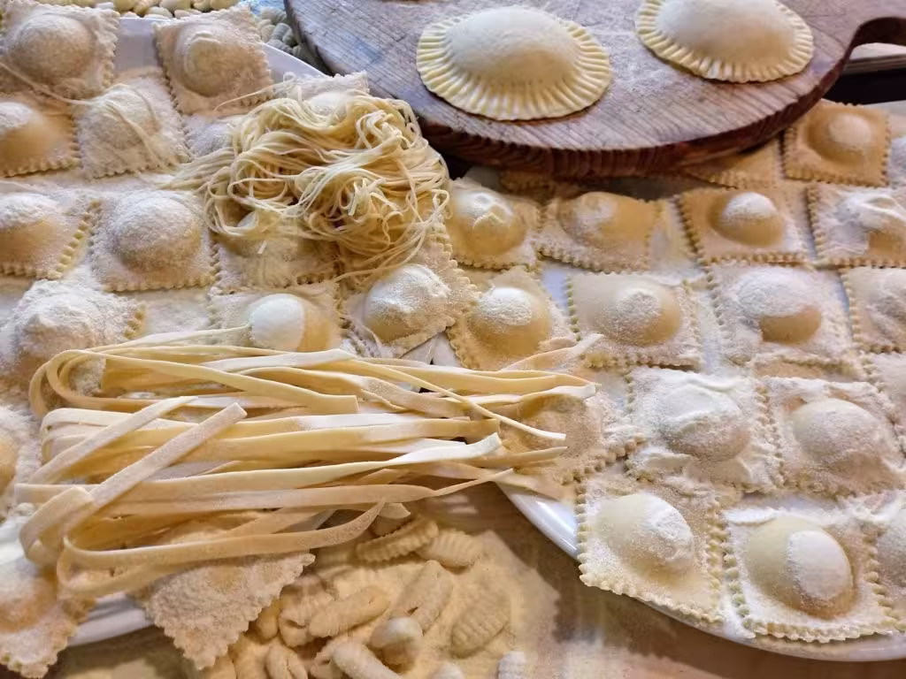 Assorted handmade pasta varieties, including ravioli and fettuccine, showcased at an Olmedo cooking class in Alghero.