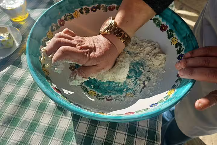 Hands kneading fresh pizza dough in rustic bowl on farm tour with cheese making, wine tasting and limoncello test