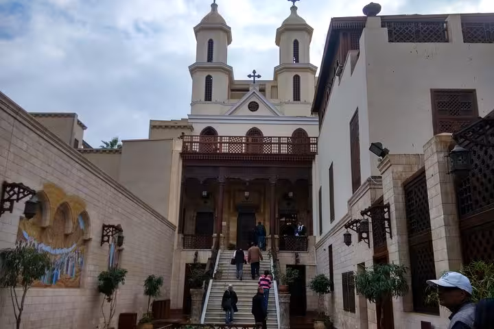 Visitors climbing steps to the Hanging Church in Coptic Cairo, a highlight of Muizz Street and bazaar day tour