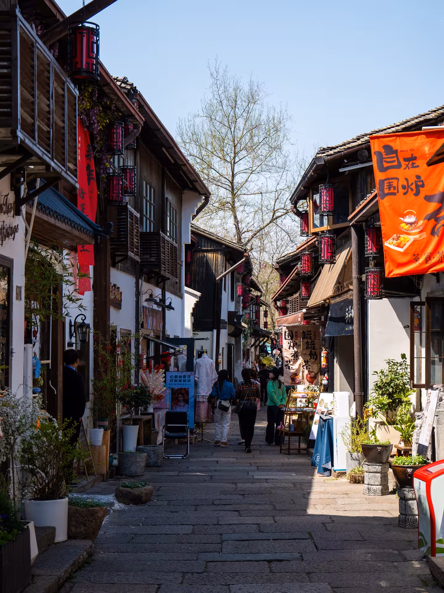 Charming street in Hangzhou with traditional shops and vibrant banners, perfect for cultural exploration.