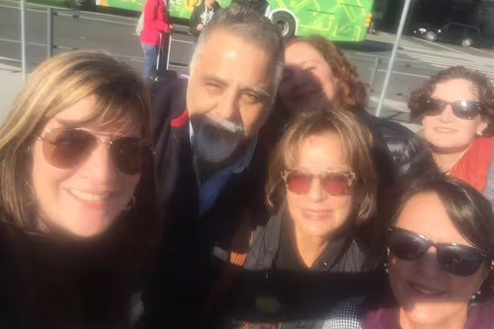 Group of happy tourists enjoying a sunny day on a private Lisbon city tour, capturing memories and exploring iconic sites.