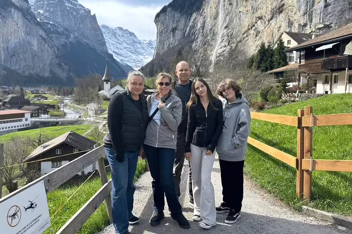 Group of tourists enjoying picturesque village and mountain backdrop on a private day trip to Harder Kulm and Grindelwald.