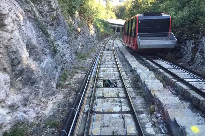 Harderbahn funicular ascending scenic rocky track towards Harder Kulm during private day trip.