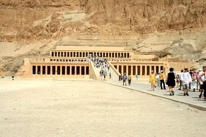 Visitors walking towards the majestic Mortuary Temple of Hatshepsut, a highlight of the West Bank Luxor tour.