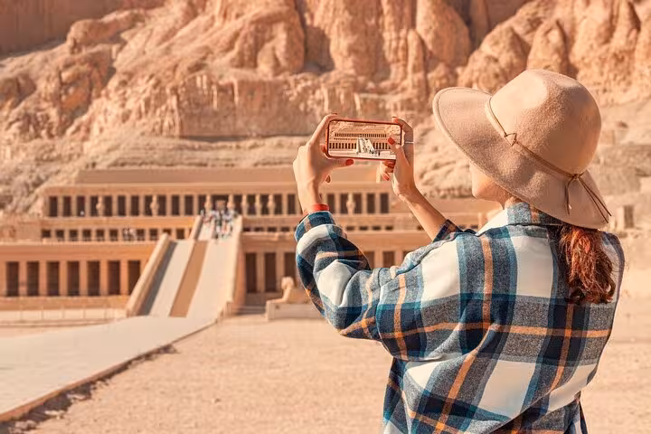 Tourist photographing Hatshepsut Temple in Luxor on a 2-day private tour from Hurghada to Abu Simbel