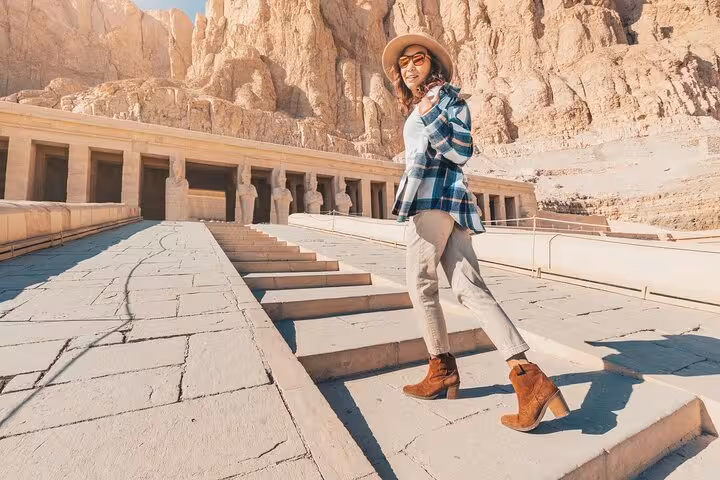 Visitor on steps at Hatshepsut Temple in Luxor, part of 2-day Hurghada tour with hotel, balloon and Nile cruise