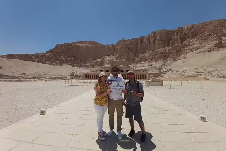 Tour group photo at Hatshepsut Temple, Luxor West Bank Nile tour, with cliffs and forecourt walkway