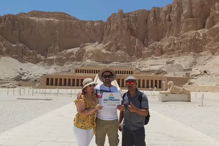 Travelers at Hatshepsut Temple in Luxor on Valley of the Kings tour, Deir el-Bahari cliffs behind
