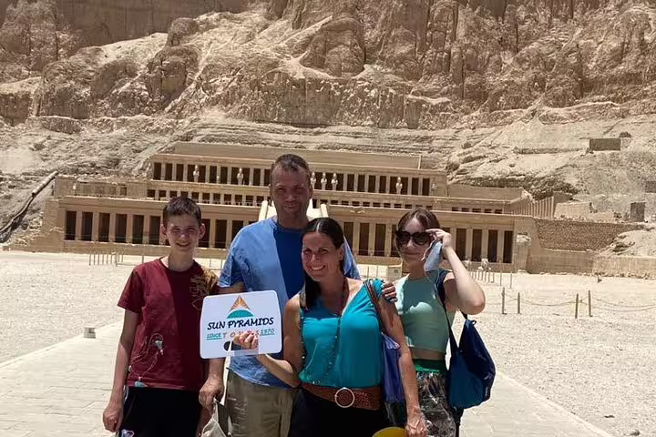 Tourists pose at Hatshepsut Temple on Luxor West Bank day tour, Egypt, with Deir el-Bahari cliffs behind