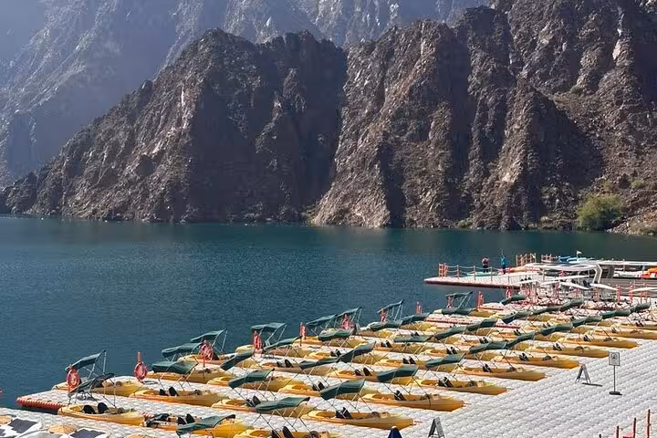 Hatta Dam marina with rows of kayaks and boats, scenic mountain views on private Hatta City Tour for 1-6