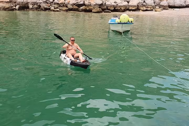 Kayaking on emerald water at Hatta Dam during private Hatta city tour, ideal for small groups up to 6