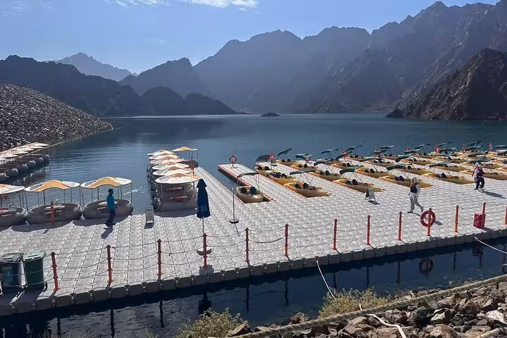 Hatta Dam floating platform with kayaks and mountain views on a private full-day Hatta tour from Dubai