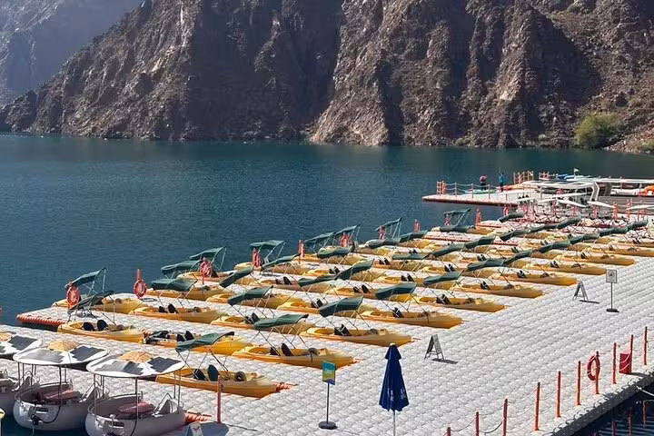Kayaks lined up at Hatta Dam Lake marina, Dubai mountains backdrop on private full-day Hatta tour