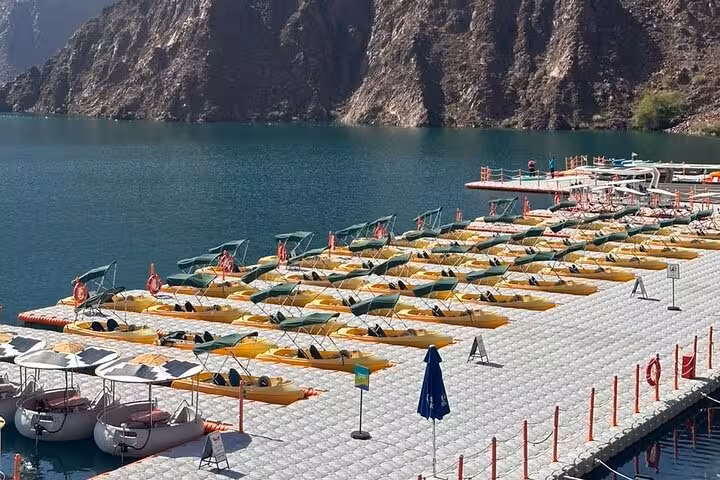 Kayaks lined up at Hatta Dam lake dock, scenic mountain views on private full-day Hatta tour from Dubai