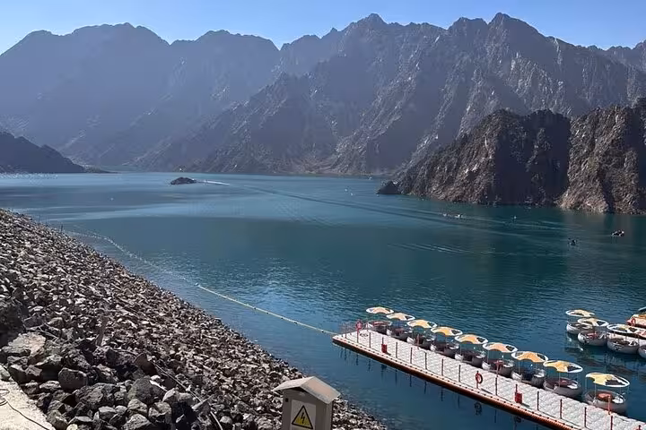 Hatta Dam turquoise lake and rugged mountains, scenic stop on private Hatta city tour for 1-6 guests