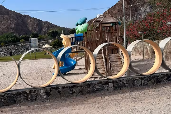 Hatta Heritage Village park playground with wooden tower and slides, scenic stop on private full-day tour