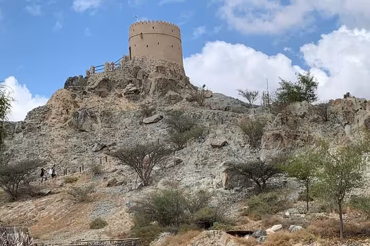 Hatta Heritage Village watchtower on rocky hill, Dubai day tour stop on private full-day trip for 1–6 pax