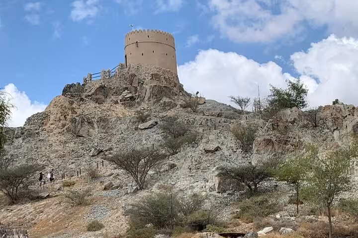 Hatta heritage watchtower on rocky hill in the Hajar Mountains, stop on a private full-day Hatta day trip