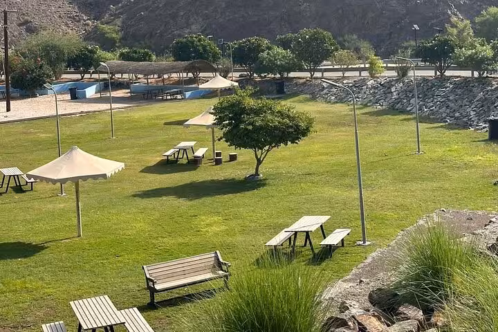 Green picnic park in Hatta with benches and shaded umbrellas, a relaxing stop on a private full-day tour