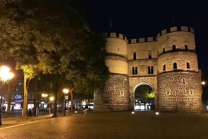 Historic Hahnentor gate tower illuminated at night in Cologne, Germany