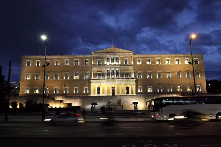 Illuminated Hellenic Parliament at Syntagma Square, Athens night tour highlight with city traffic